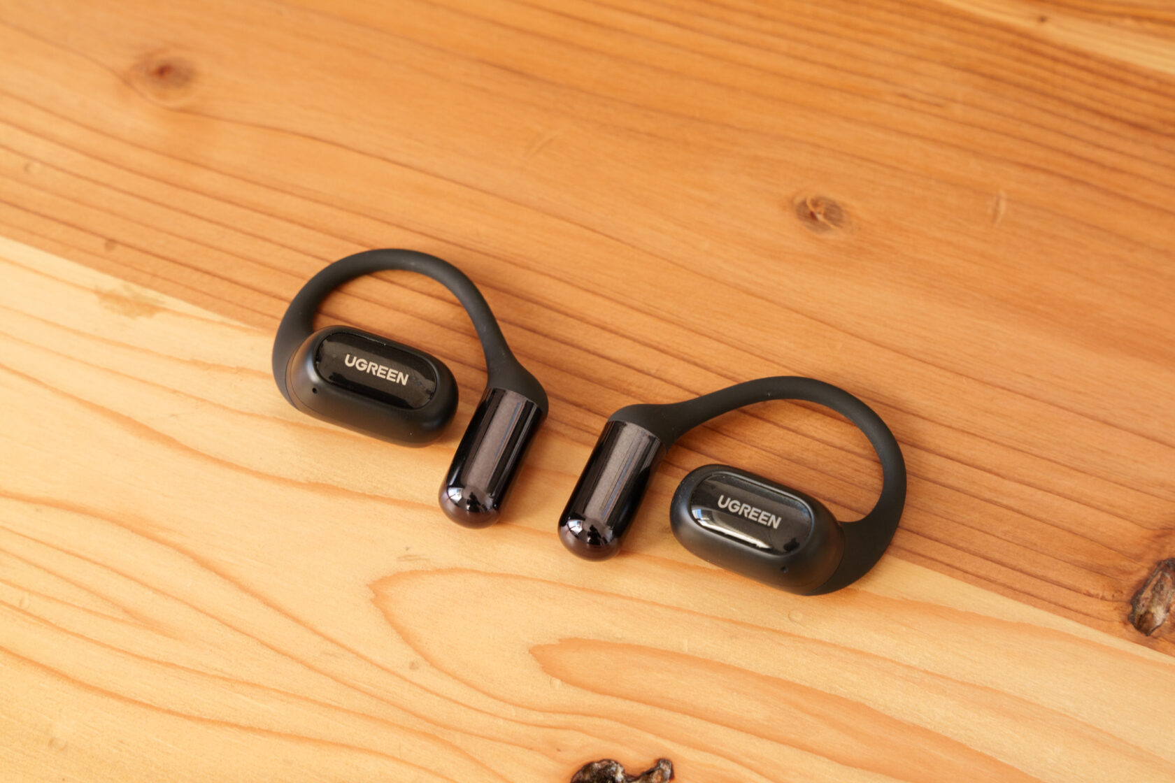 木の上に並べたUGREENのオープンイヤー型イヤホン